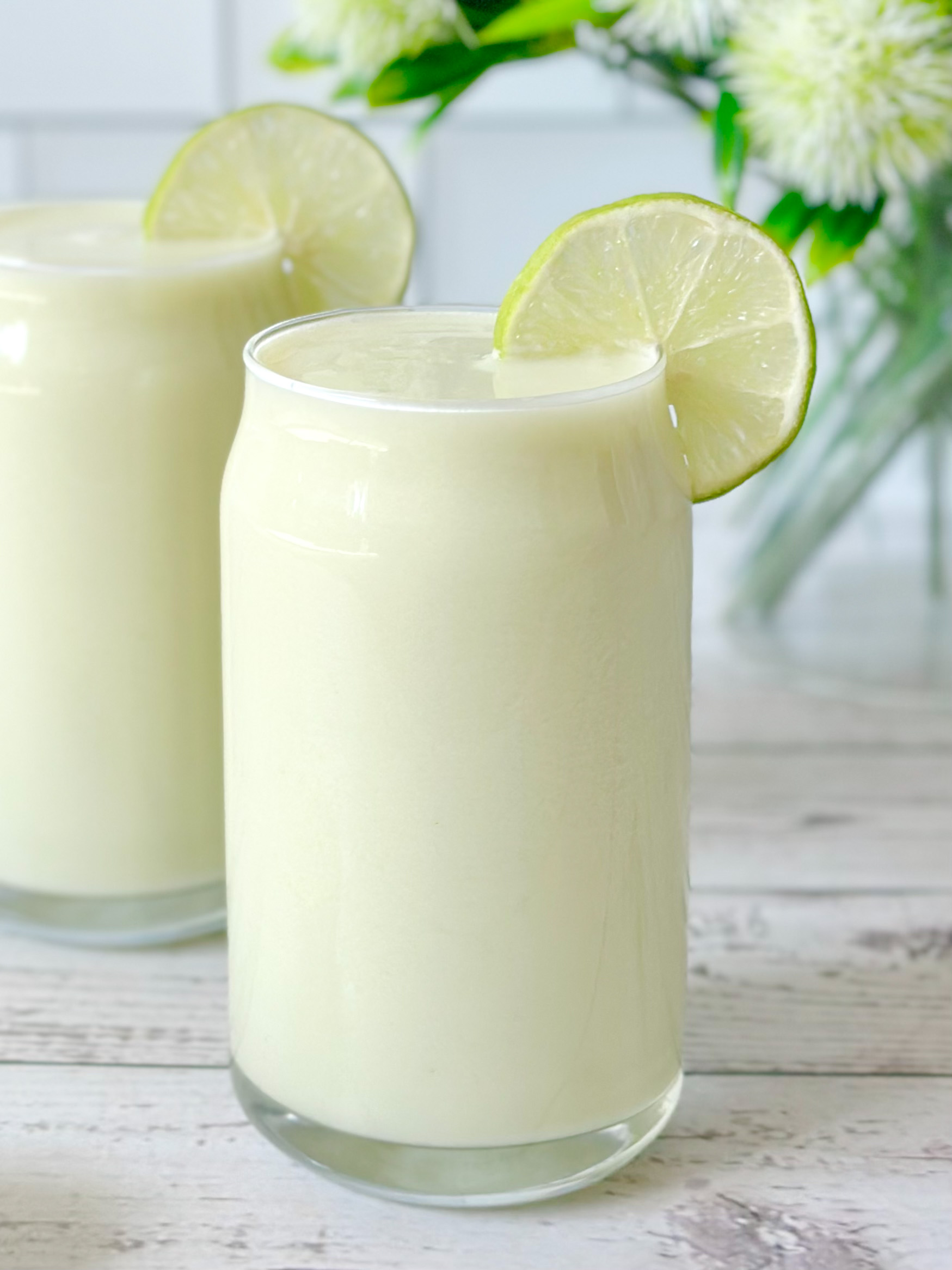 two finished Brazilian lemonades made with fresh limes, coconut water, and coconut milk.
