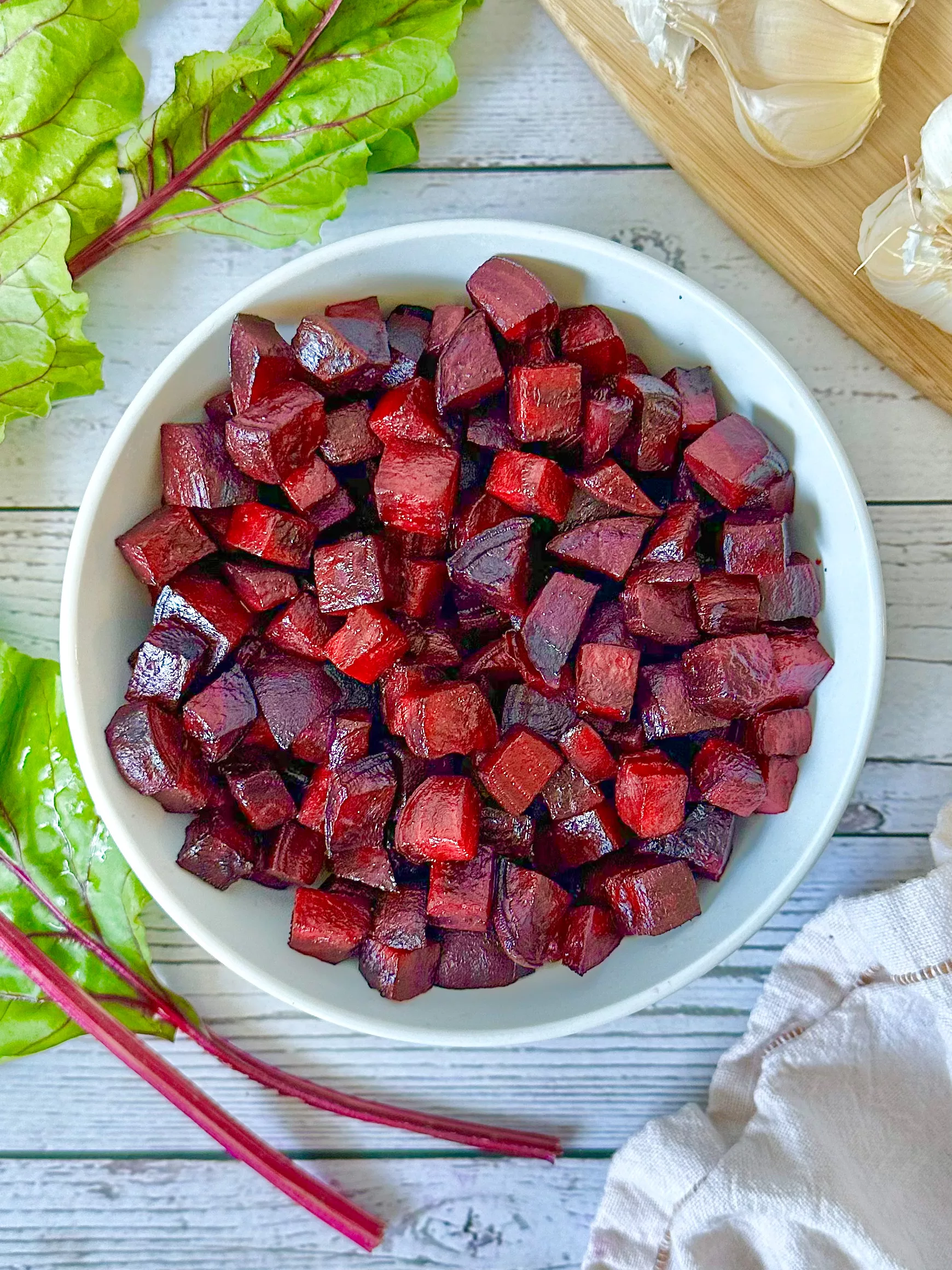 white bowl of crispy air-fried beet cubes with a sprinkle of sea salt and garlic powder, ready to be enjoyed.