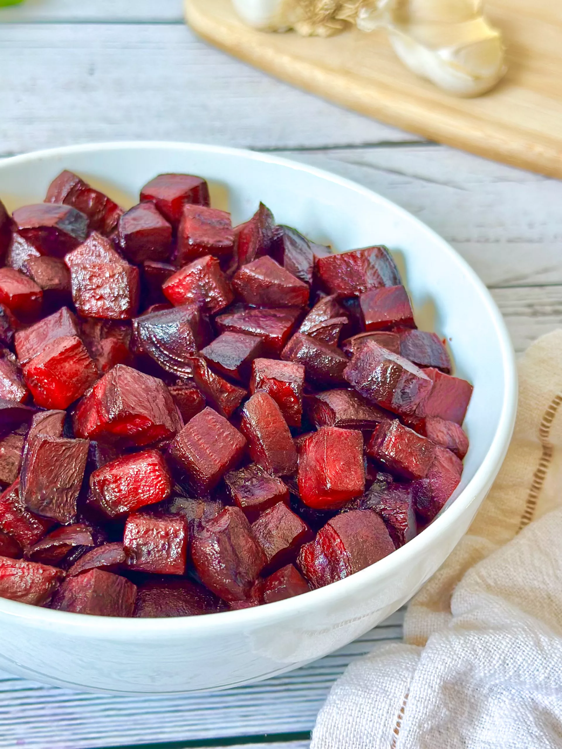 white bowl of crispy air-fried beet cubes with a sprinkle of sea salt and garlic powder, ready to be enjoyed.