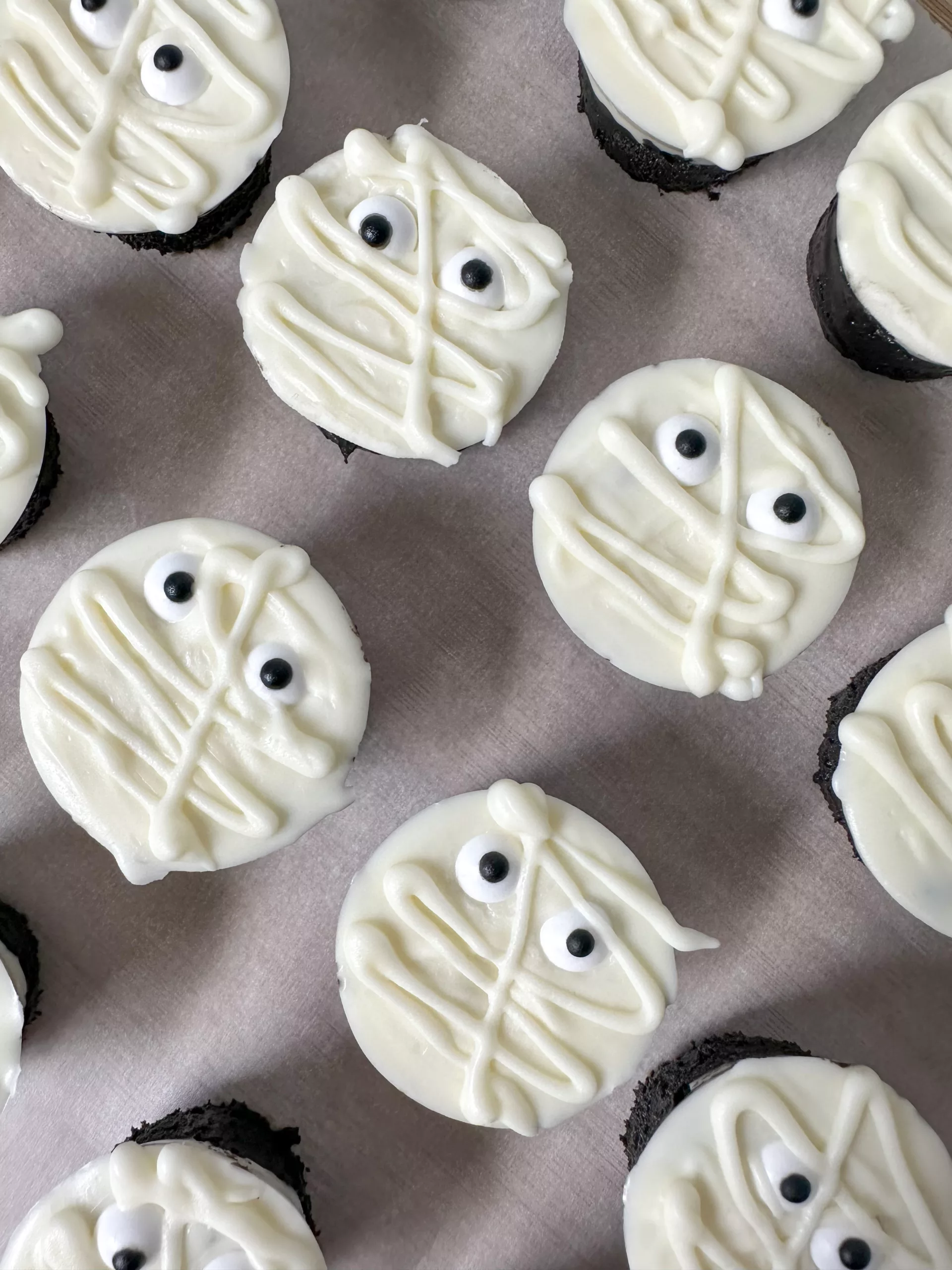 Mummy Rice Krispie treats laying on parchment paper for a fun halloween treat