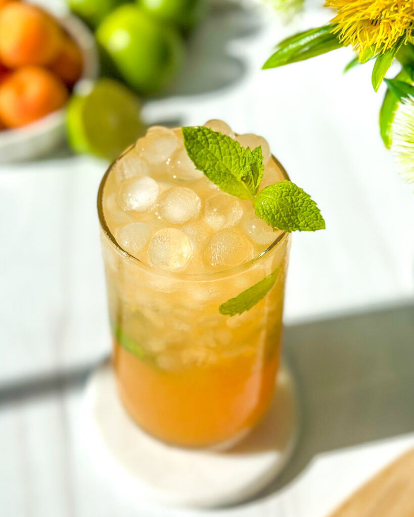 Fresh apricot mojito cocktail with mint and lime photographed from a slight overhead angle