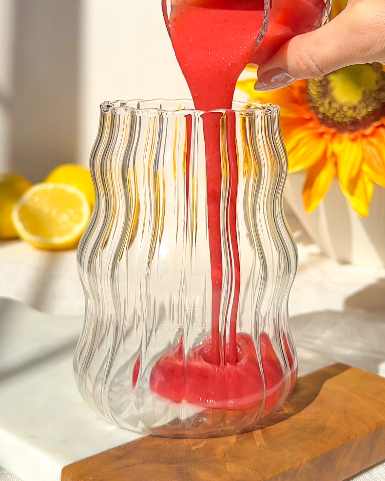 strawberry puree being poured into a glass
