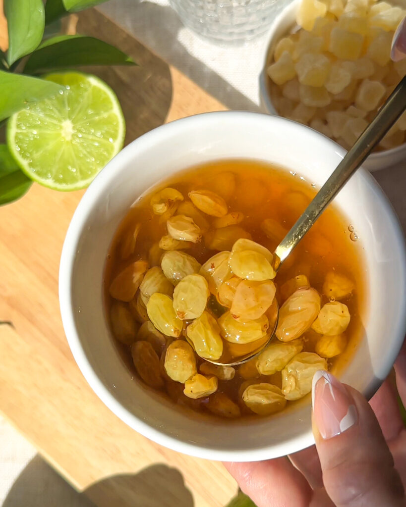 close up process shot of soaking golden raisins in rum to make golden raisin syrup for pineapple rum spritz cocktail