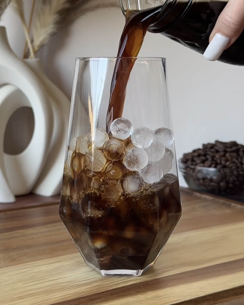 pouring cold brew coffee into a glass for tiramisu cold brew iced coffee
