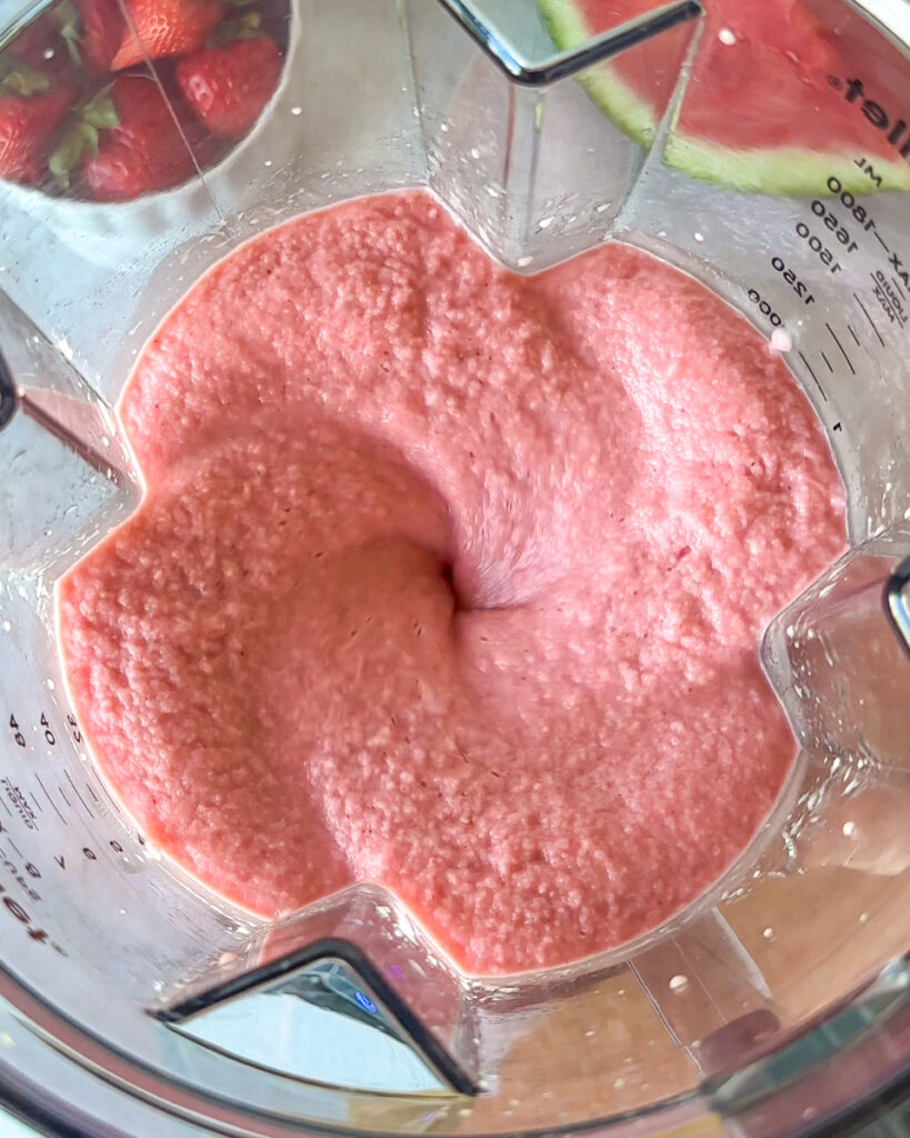 over head close up of strawberry watermelon smoothie being blended