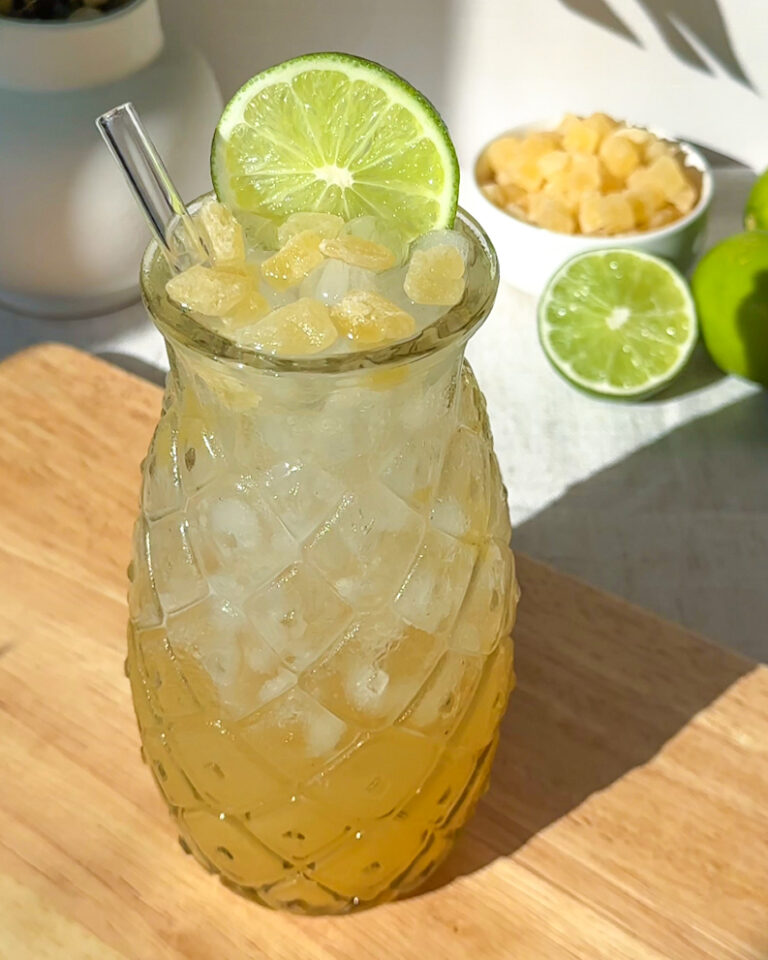 pineapple rum spritz cocktail served over ice and garnished with with fresh lime wheel and dried pineapple cubes