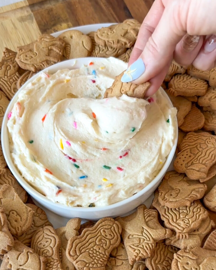 Dipping an animal cracker into creamy homemade Dunkaroo dip.