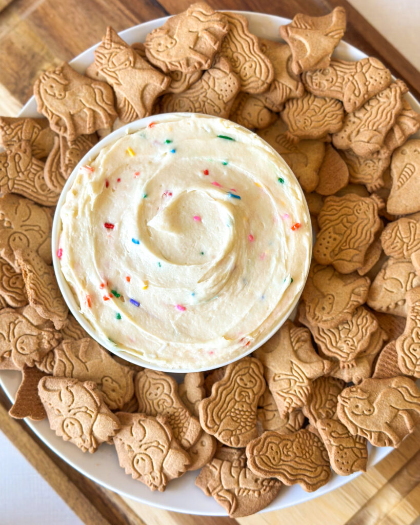 Overhead view of homemade Dunkaroo dip served with animal crackers and sprinkles.