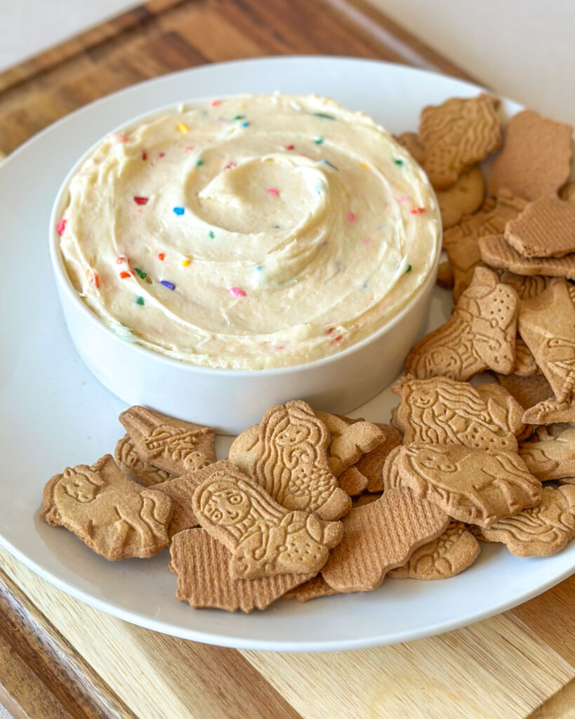 Close-up of creamy homemade Dunkaroo dip topped with colorful sprinkles.
