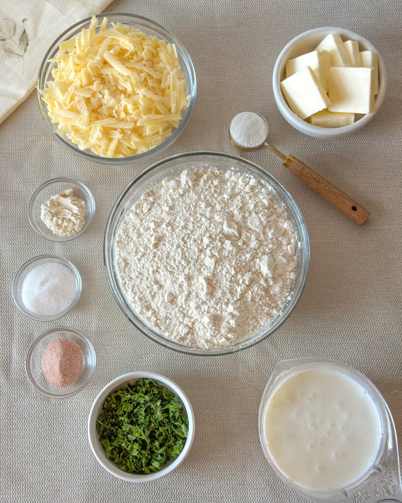 Ingredients for homemade Cheddar Bay swim Biscuits including flour, cheddar cheese, butter, buttermilk, garlic powder, salt, and parsley