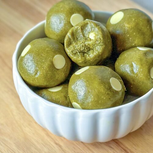 Close-upfront view of vegan matcha cookie dough balls overflowing from a bowl