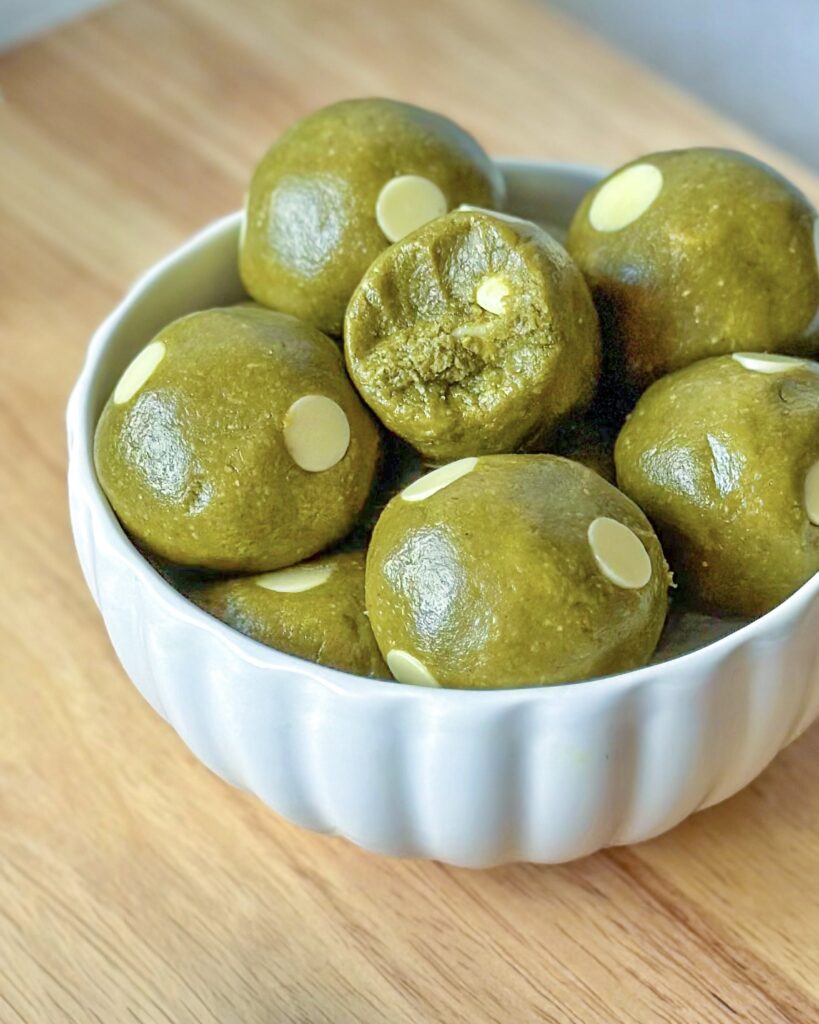 Close-upfront view of vegan matcha cookie dough balls overflowing from a bowl
